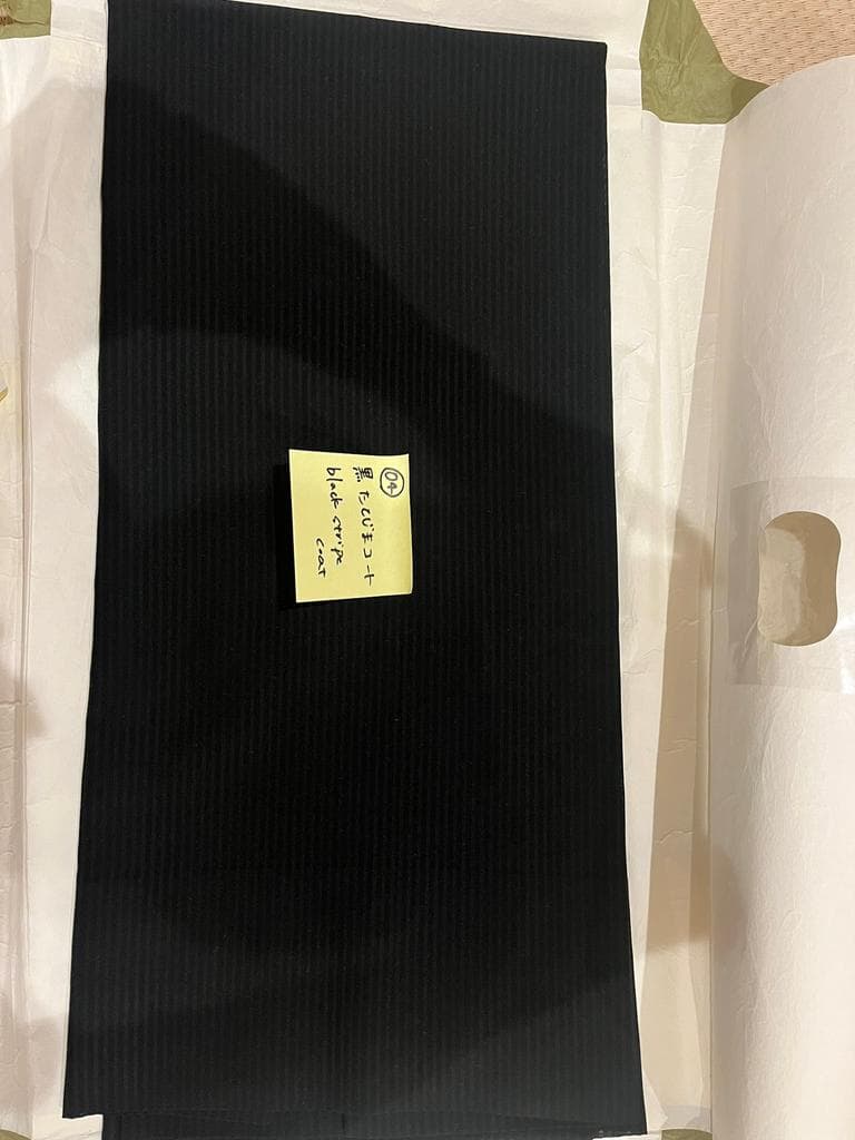 Black ribbed coat on white background.