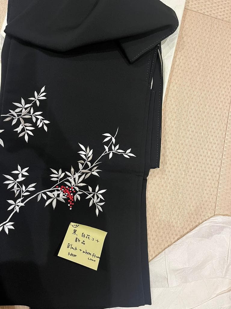 Folded black coat with white floral pattern and red accents.