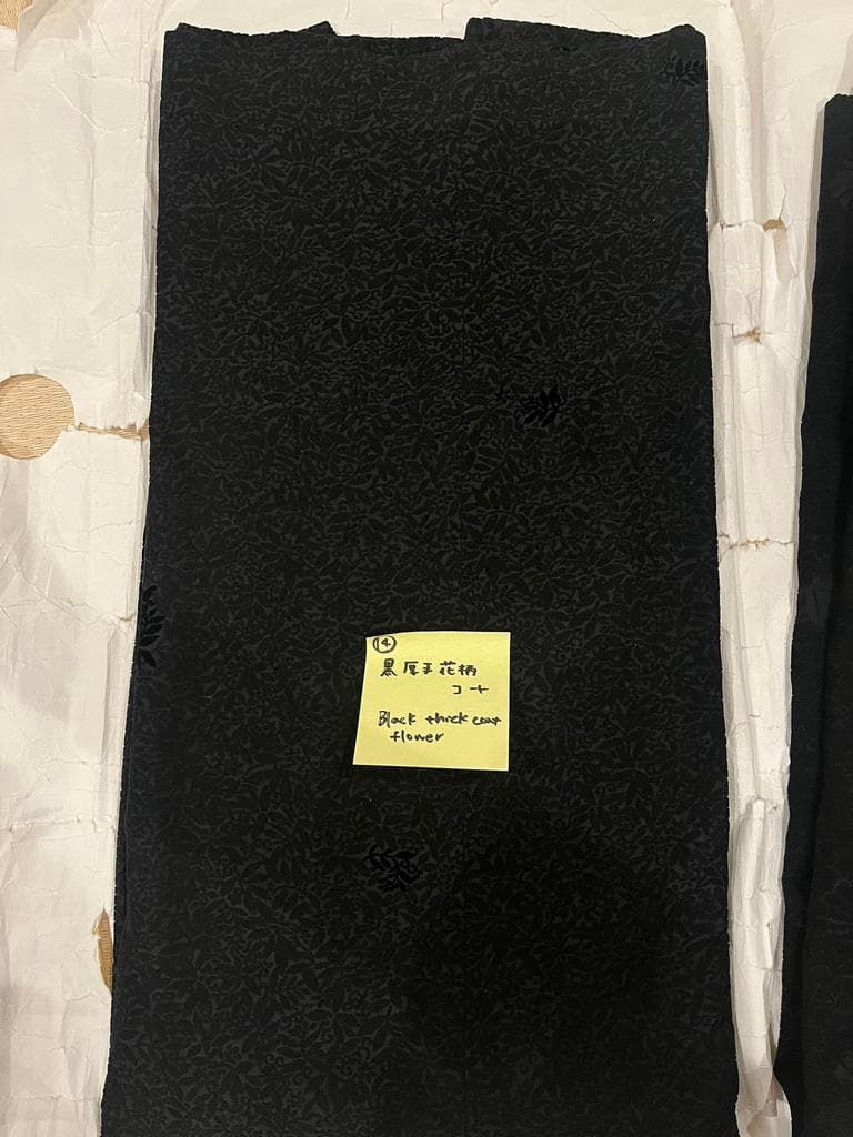 Close-up of black coat with floral pattern.