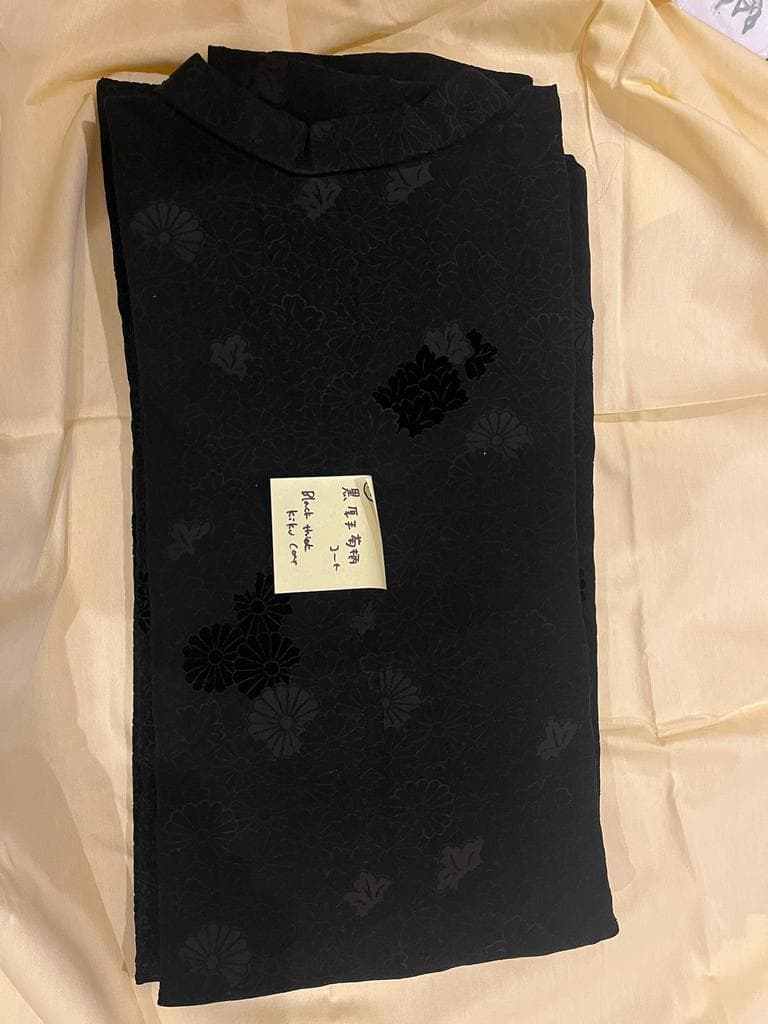 Folded black coat with chrysanthemum pattern.