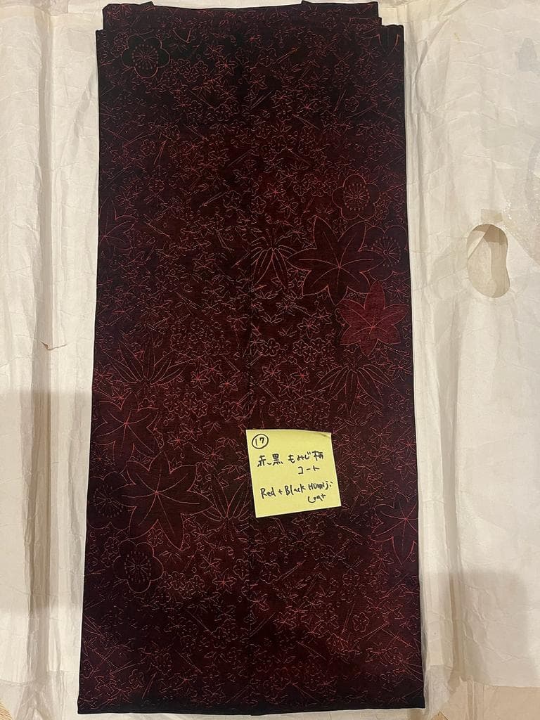 Folded red and black coat with momiji pattern.