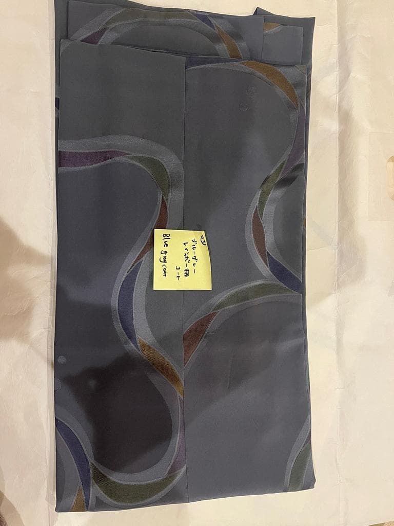 Folded blue-grey coat with wave pattern.